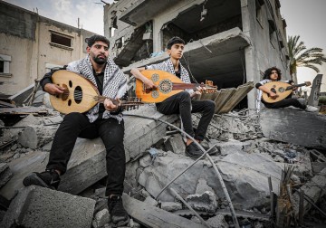 فرقة موسيقية تعزف فوق ركام أحد المنازل التي دمرها الاحتلال في العدوان الأخير