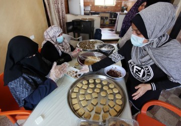 نساء فلسطينيات يقمن بإعداد الكعك المحلى لبيعها إلى الزبائن قبل عيد الفطر  غزة