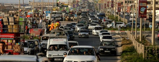 الآلاف من الغزّيين يستجمون على شاطئ بحر غزة في أول أيام فصل الصيف. - تصوير: محمود الهمص 