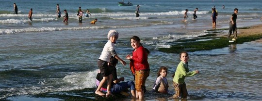 أطفال يلهون على شاطئ بحر غزة