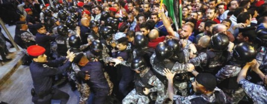اشتباكات بين الأمن ومتظاهرين أمام مكتب رئيس الوزراء في عمّان أمس (رويترز)