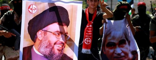 نشطاء في الجبهة الشعبية يرفعون لافتات تحمل صور الأمين العام لحزب الله اللبناني في واحدة من فعالياتها الوطنية