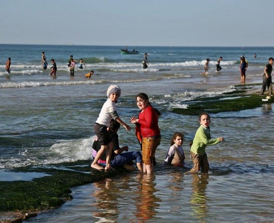 أطفال يلهون على شاطئ بحر غزة