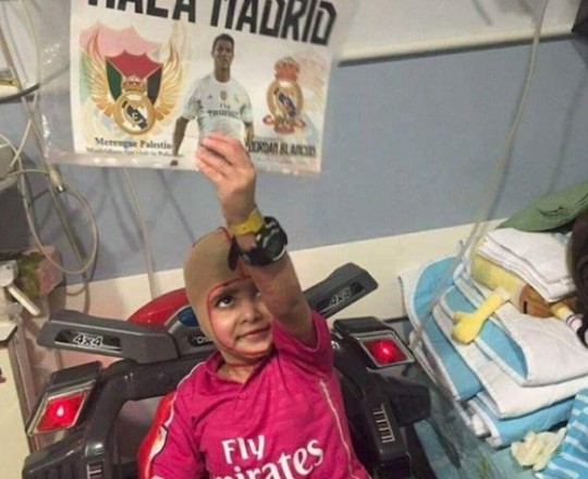 الطفل دوابشة رافعًا صورة النجم رونالدو وشعار مدريد - أرشيف 