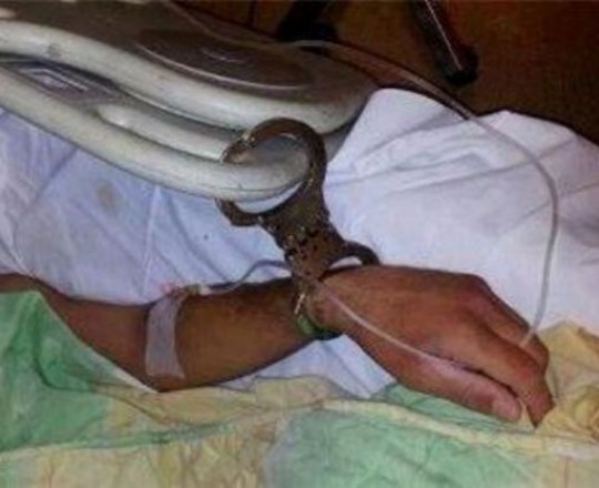 ارشيف- اسير مريض، مُقيد بالسلاسل في السرير