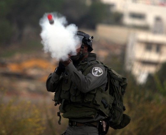 ارشيفية - جندي صهيوني يطلق الغاز على الفلسطينيين