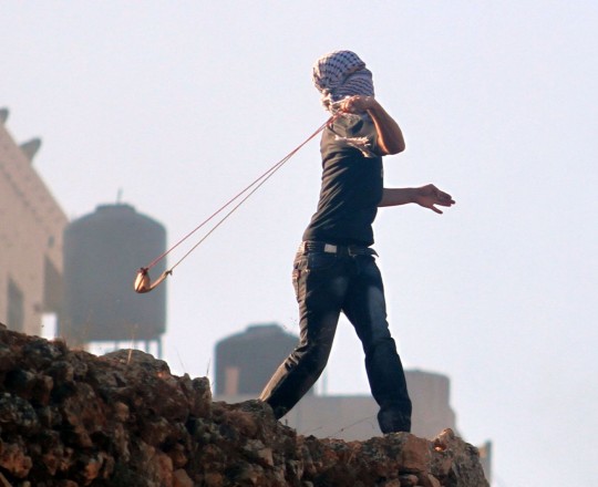 شاب يرشق الحجارة