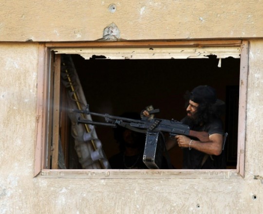 احد عناصر قوات المشير خليفة شرق ليبيا يتبادل اطلاق النار مع مسلحين في منطقة بنغازي في 17 تموز/يوليو 2017. 