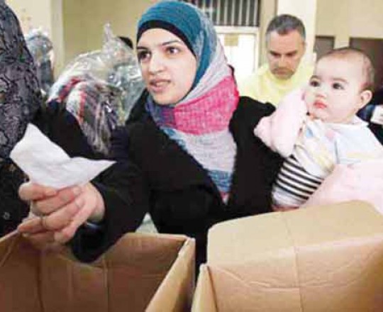 أم سورية أثناء تلقي المساعدات الإنسانية