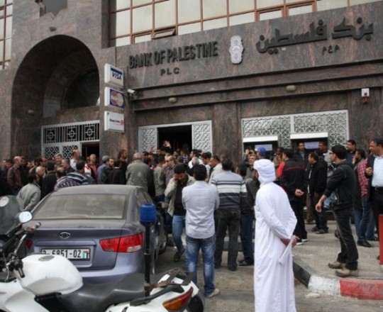 موظفين يتلقون رواتبهم عبر أحد أفرع بنك فلسطيني بغزّة