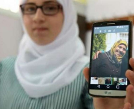 طالبة تظهر هاتفها وعليه صورة معلّمتها رسهام دوابشة التي أحرقها مستوطنون بنابلس