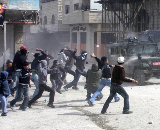شبان فلسطينيّون يُرشقون مركبة لجيش الاحتلال بالحجارة- أرشيفية